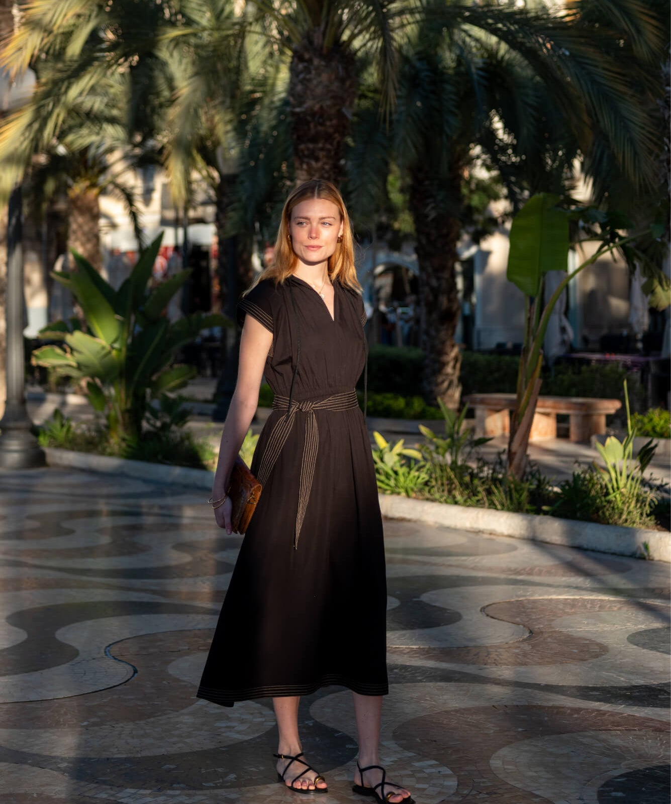 Black maxi dress with short sleeves and a cinched waist featuring subtle striped accents.