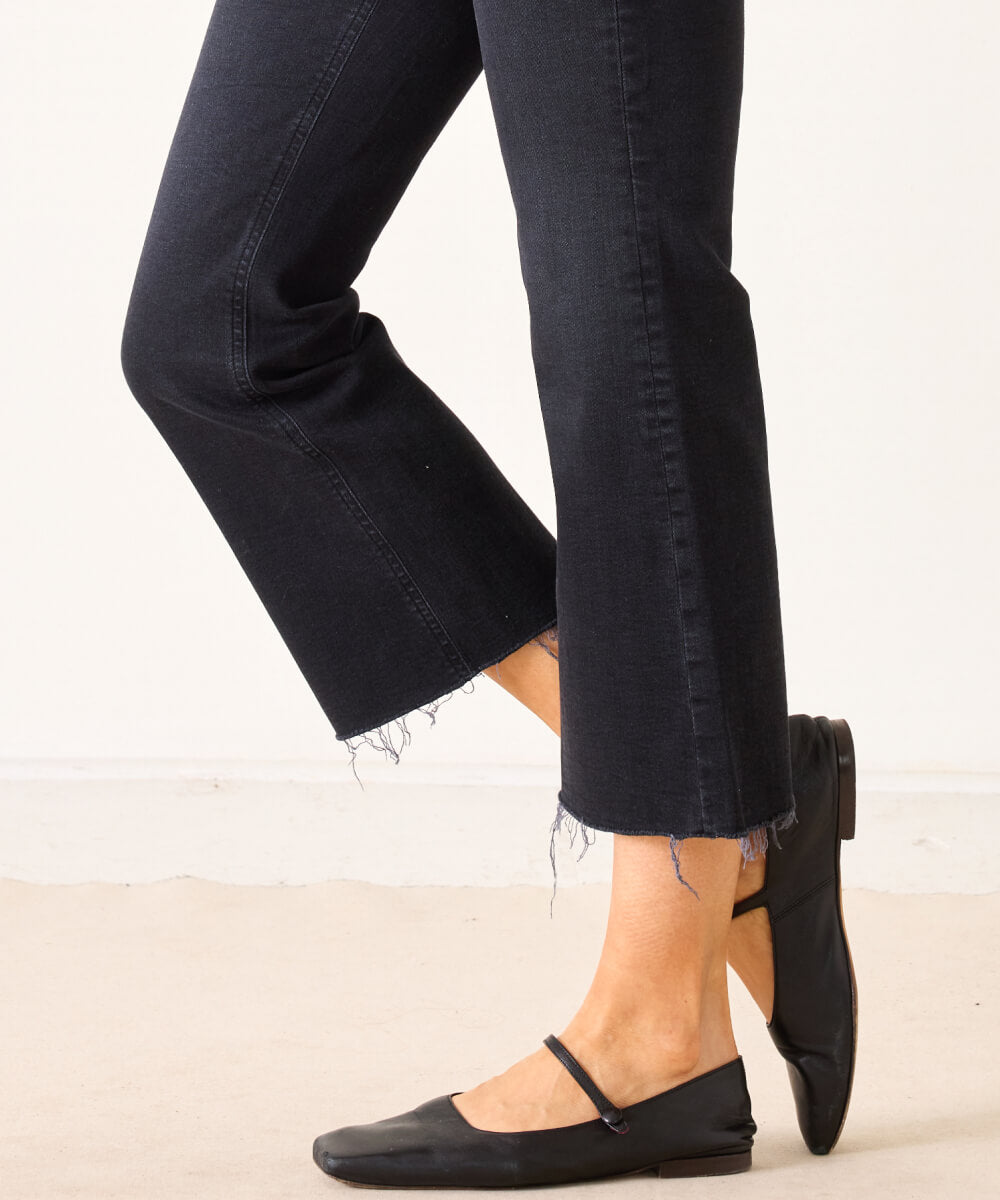 Black cropped wide-leg denim pants with frayed hems and leather pointed-toe flat shoes.