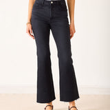 Person wearing black flared jeans on a white background