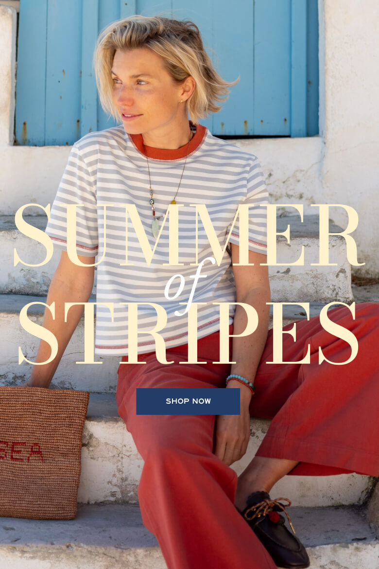 Striped t-shirt in blue and white with orange trim over red trousers.
