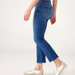 lower body side view of Woman wearing Mersea Infinity blue Nomad cropped mini boot-cut jeans standing on white background