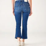 lower body rear view of Woman wearing Mersea Infinity blue Nomad cropped mini boot-cut jeans standing on white background