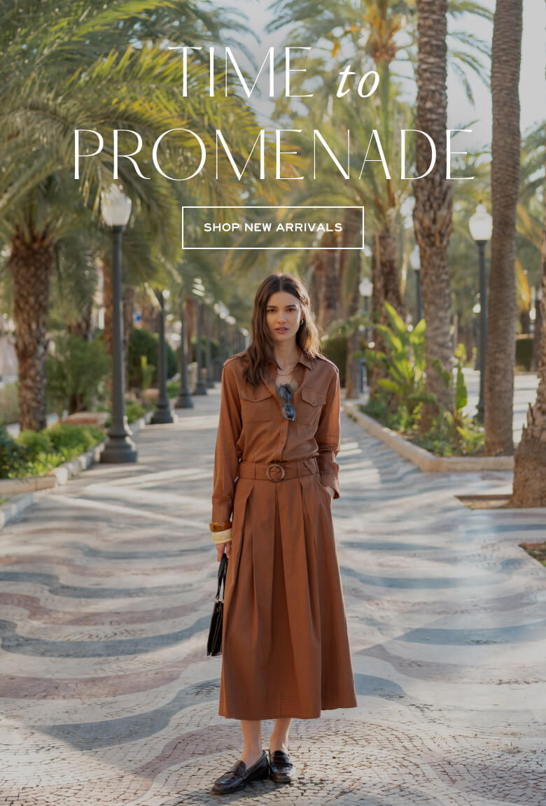A woman in a burnt orange dress walks along a coastal path lined with palm trees. Text: TIME to PROMENADE SHOP NEW ARRIVALS