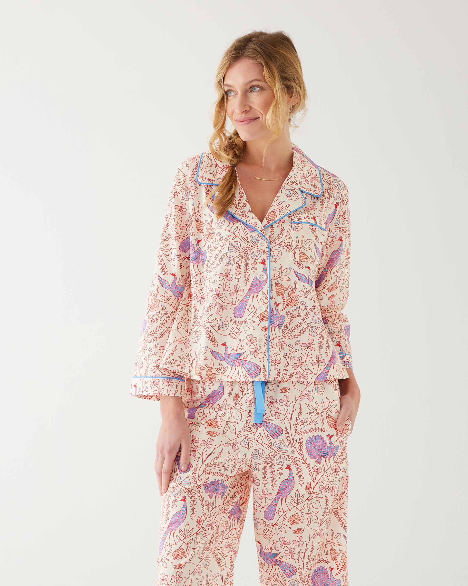 woman wearing mersea matching pajama set with peacock vines print