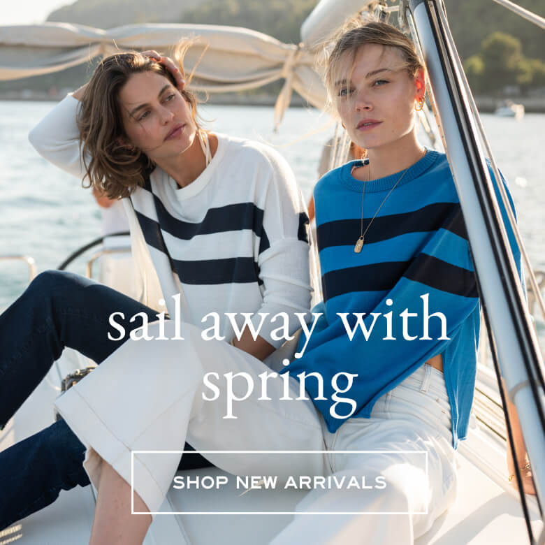 Text overlay: sail away with spring - Button "Shop New Arrivals", Image: two women sitting on a boat wearing sweaters with side slits and double stripes