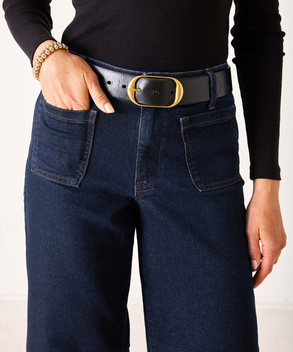 MERSEA ladies' travel-ready dark indigo denim jeans with front pockets and a gold-buckle belt.
