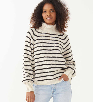 female wearing black and neutral striped wide neck turtleneck sweater on a white background