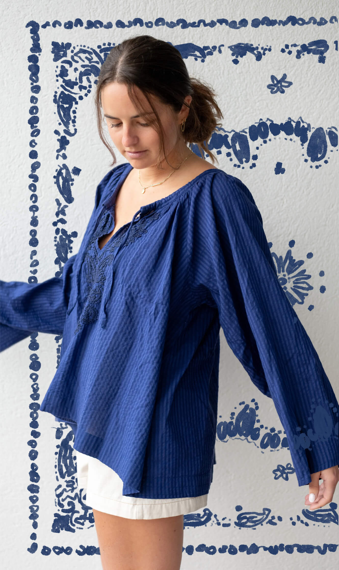 Woman wearing a blue blouse against a decorative blue and white background
