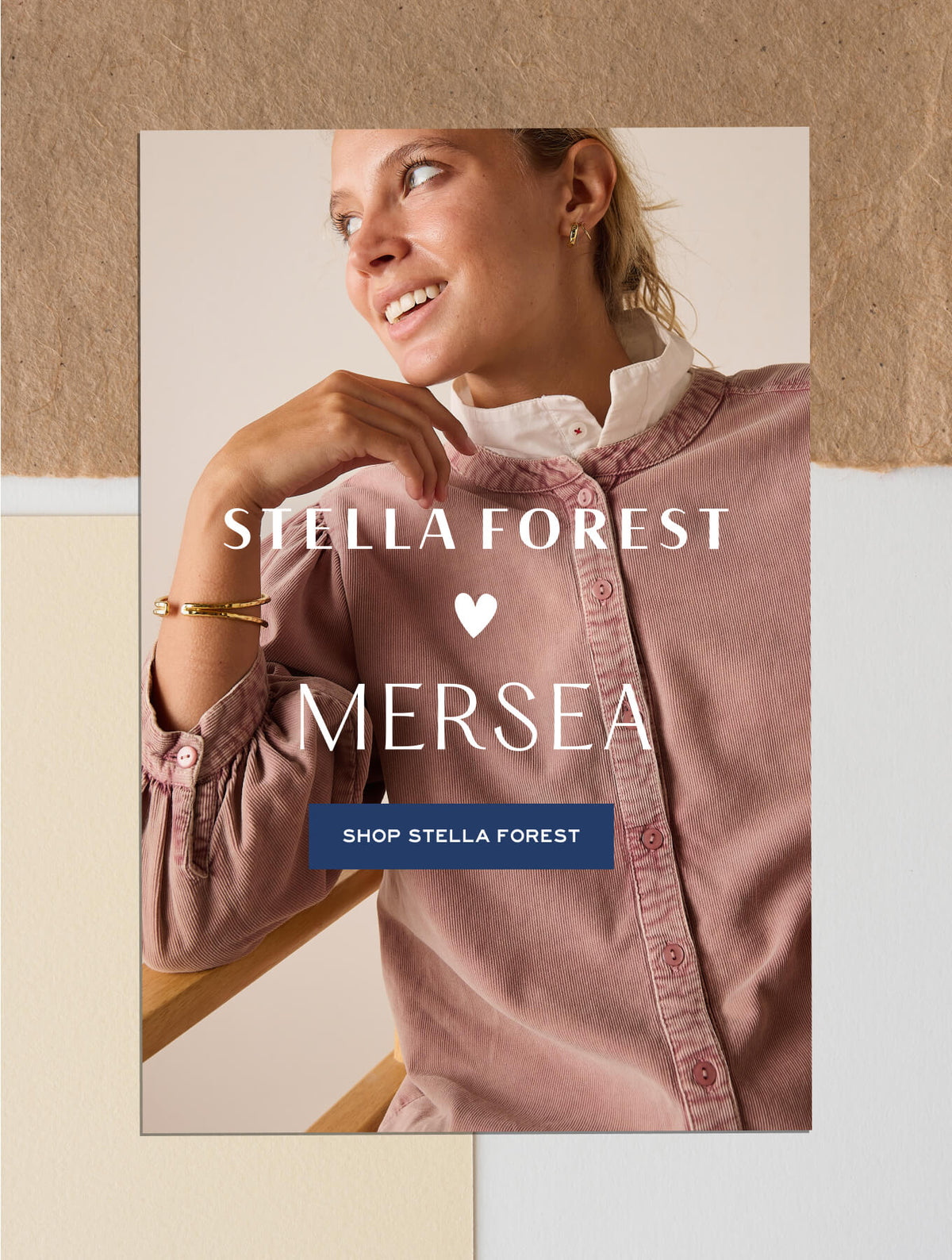 Promotional banner featuring a woman in a pink button-down shirt with a heart icon and collaborative branding. Text: STELLA FOREST, MERSEA, SHOP STELLA FOREST