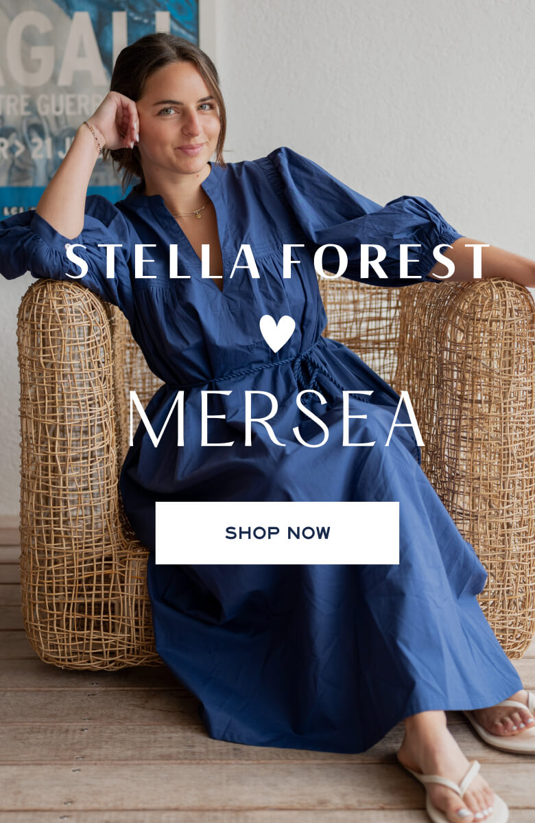 Woman in a blue dress sitting on a wicker chair with 'Stella Forest' branding.