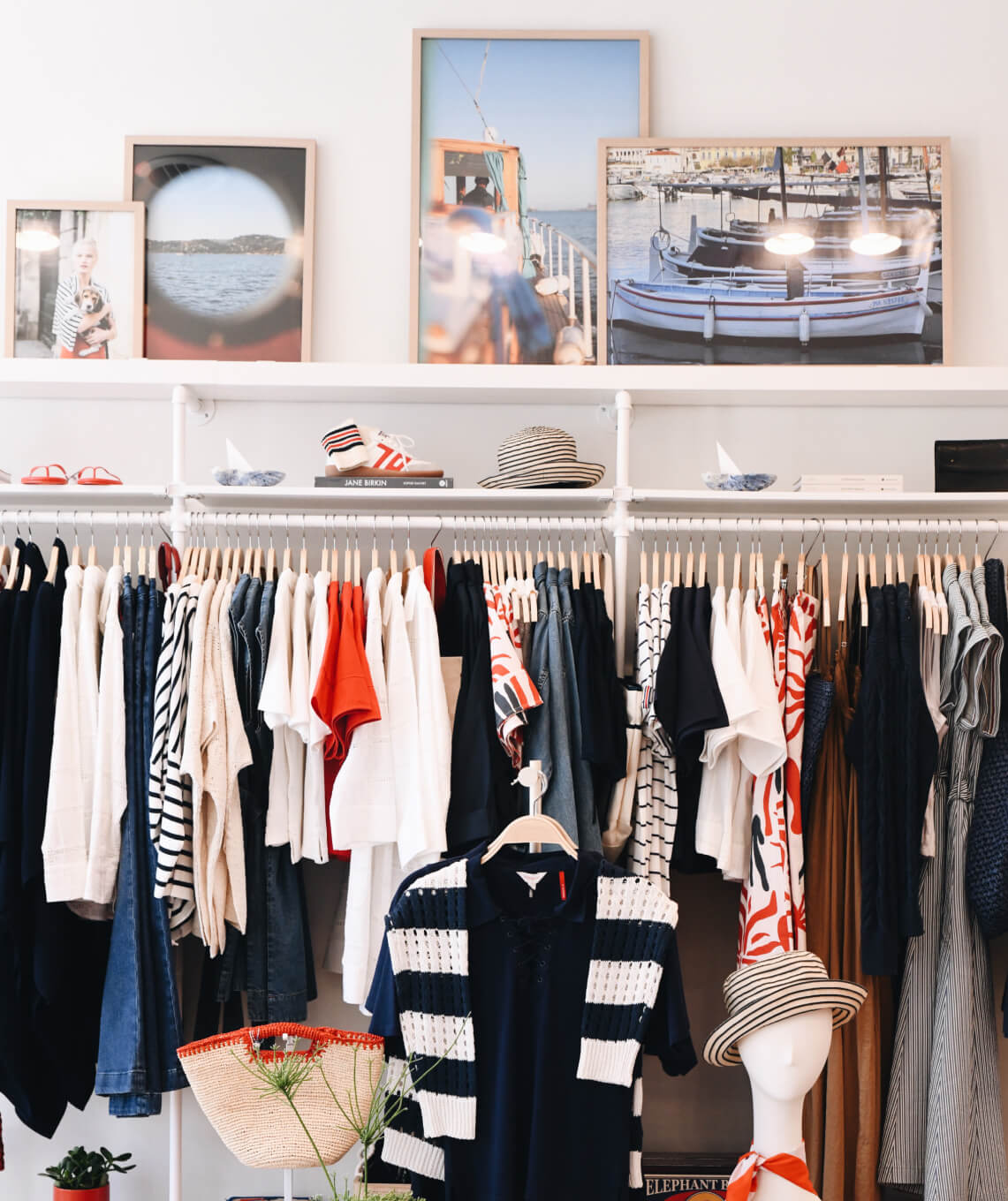 Closet with clothes on hangers and framed pictures on the wall