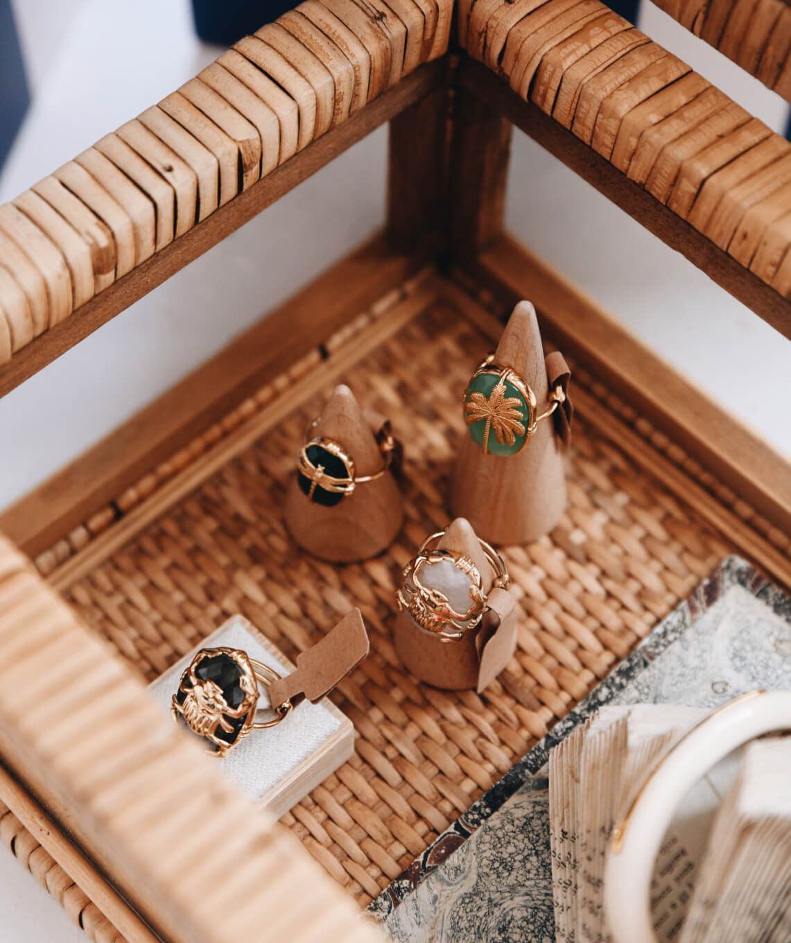 Jewelry displayed on a woven tray with a neutral background