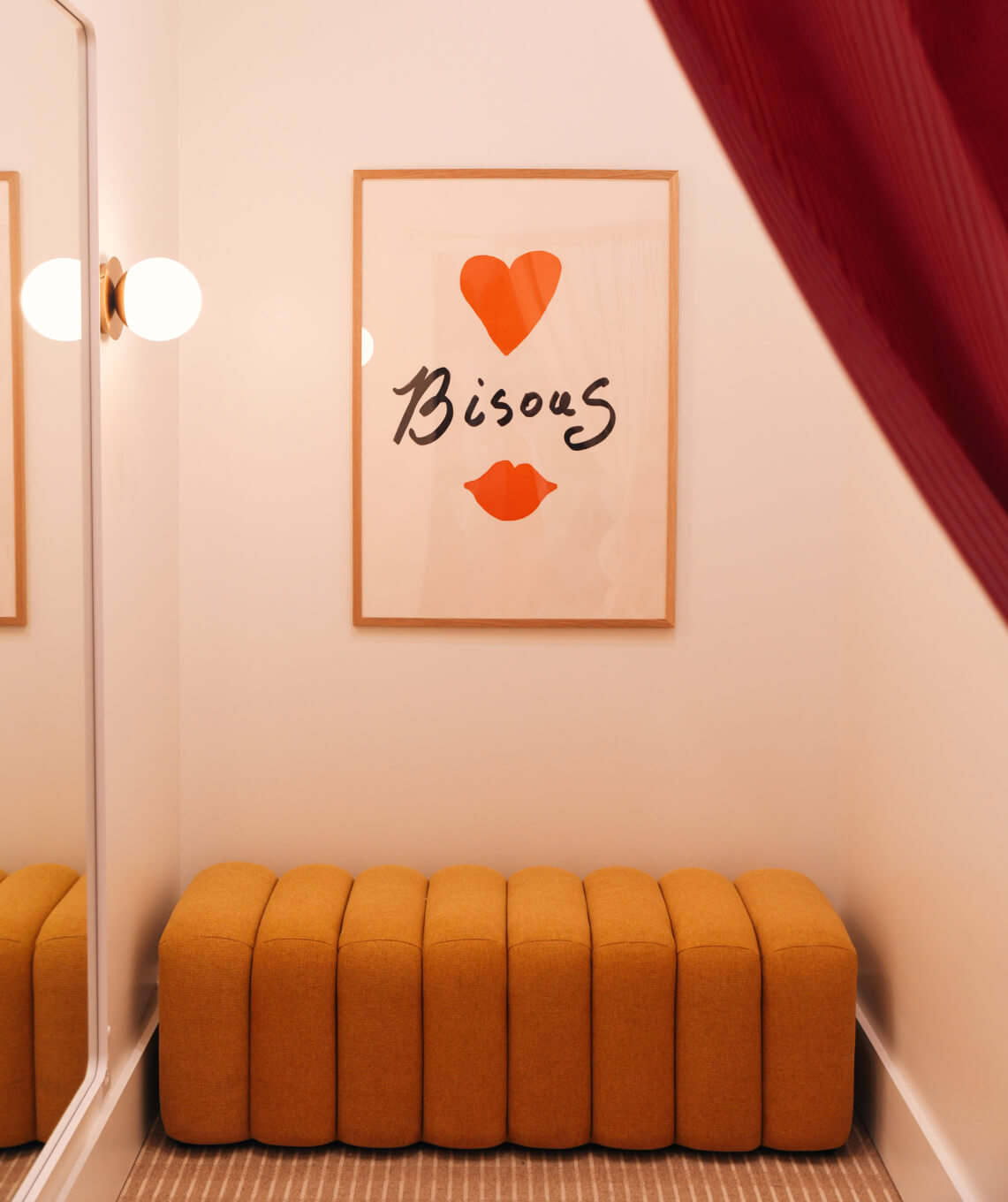 Orange ottomans in a room with a framed artwork on the wall.