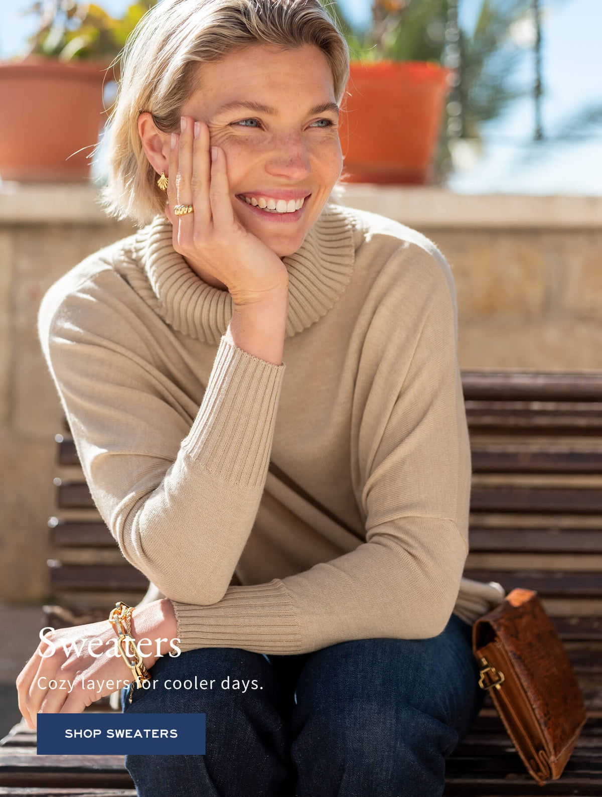 Promotional banner for knitwear featuring a smiling woman in a beige ribbed turtleneck sweater. Text: 'Sweaters / Cozy layers for cooler days. SHOP SWEATERS'