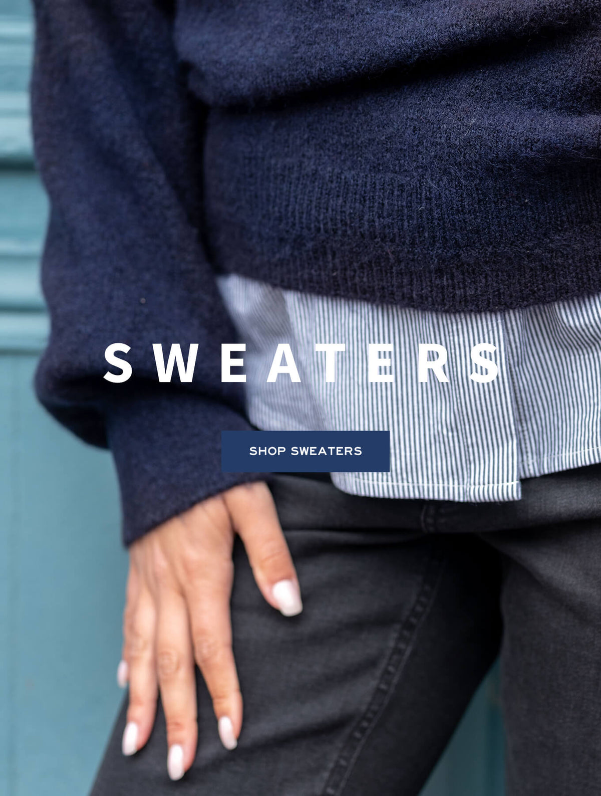 Promotional banner for a sweater collection featuring a close-up of a navy blue knit sweater with a striped hem and a woman's hand. Text: 'SWEATERS', 'SHOP SWEATERS'