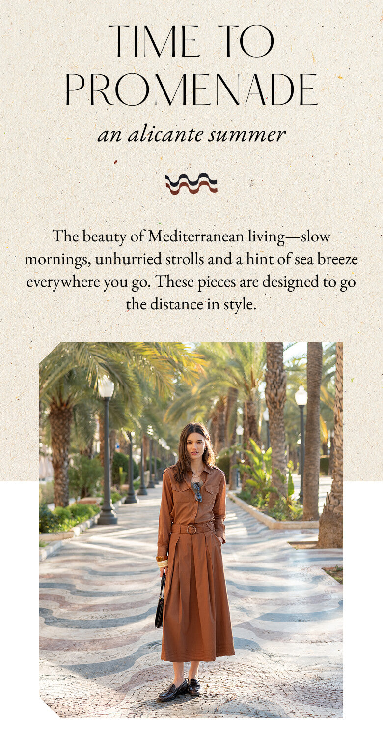 Promotional banner for the 'Time to Promenade' collection. Text: 'TIME TO PROMENADE an alicante summer'. Underneath a decorative wavy line, a paragraph reads: 'The beauty of Mediterranean living—slow mornings, unhurried strolls and a hint of sea breeze everywhere you go. These pieces are designed to go the distance in style.' A woman is pictured below wearing a long, burnt-orange wrap dress with a belt, standing on a paved walkway lined with palm trees.