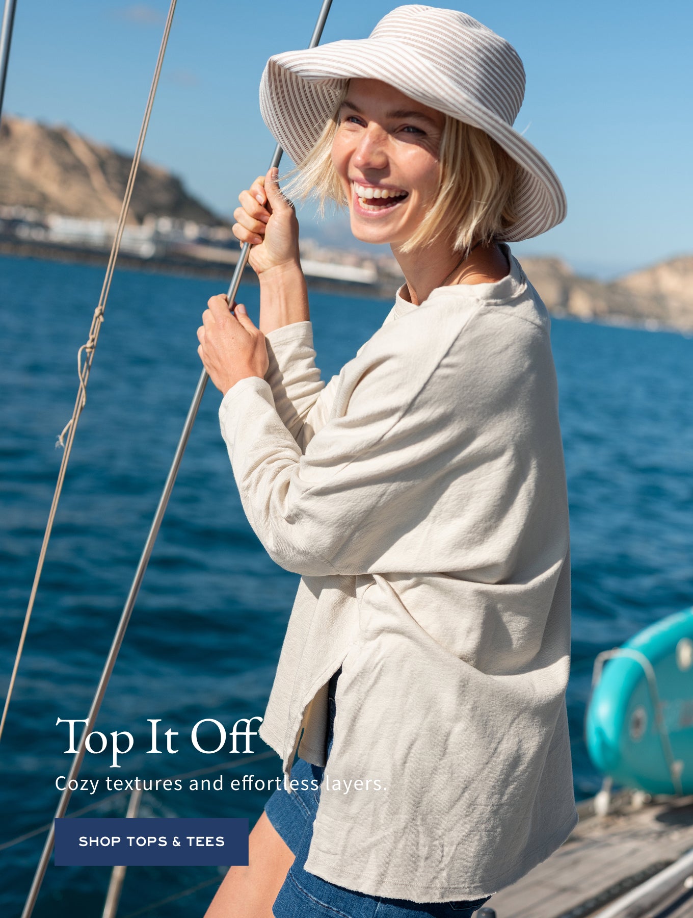 Cream tunic top with a relaxed fit and long sleeves over denim shorts. Text: Top It Off Cozy textures and effortless layers. SHOP TOPS & TEES