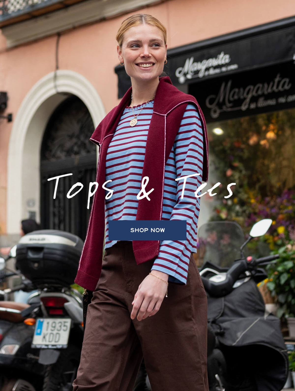 Promotional banner for MERSEA featuring a woman in a striped top and vest. Text: 'Tops & Tees SHOP NOW'