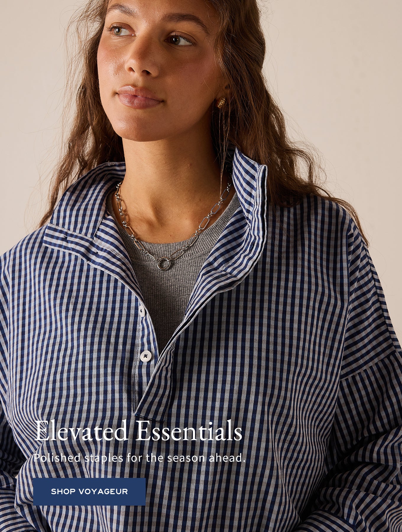 Blue and white gingham button-down shirt with a notched collar. Text: Elevated Essentials Polished staples for the season ahead. SHOP VOYAGEUR