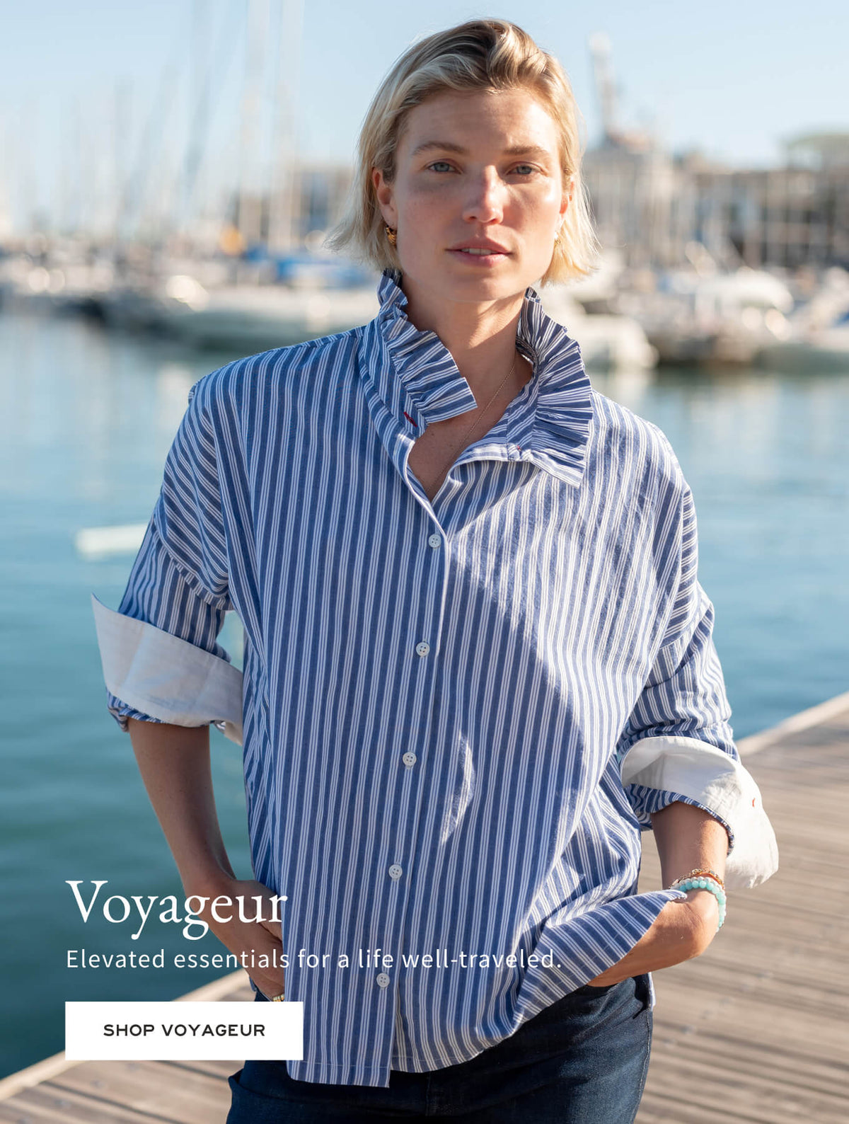 Voyageur - 
Elevated essentials for a life well-traveled. - Shop Voyageur - Image of a woman standing on a dock wearing a blue stripe top with an Elizabethan ruffle collar.