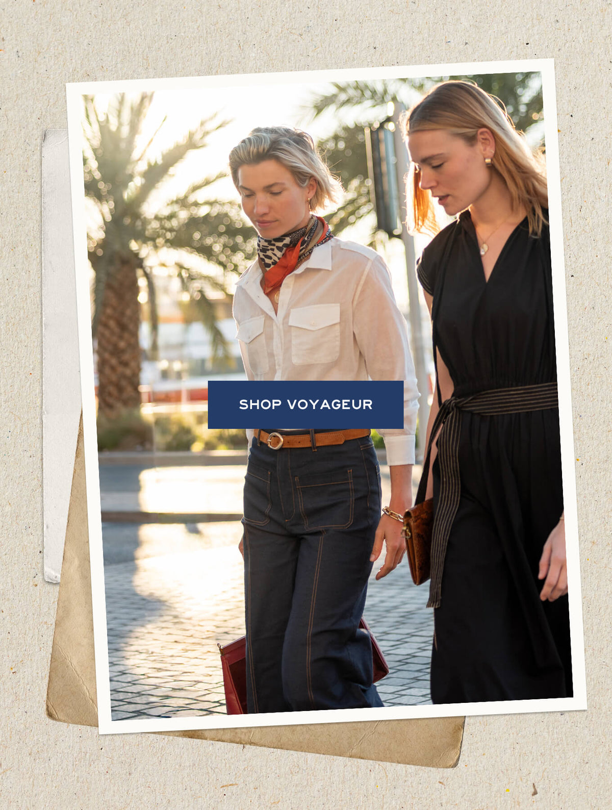 A lifestyle photo of two women in resort wear standing outdoors. Superimposed button-style banner with text: SHOP VOYAGEUR