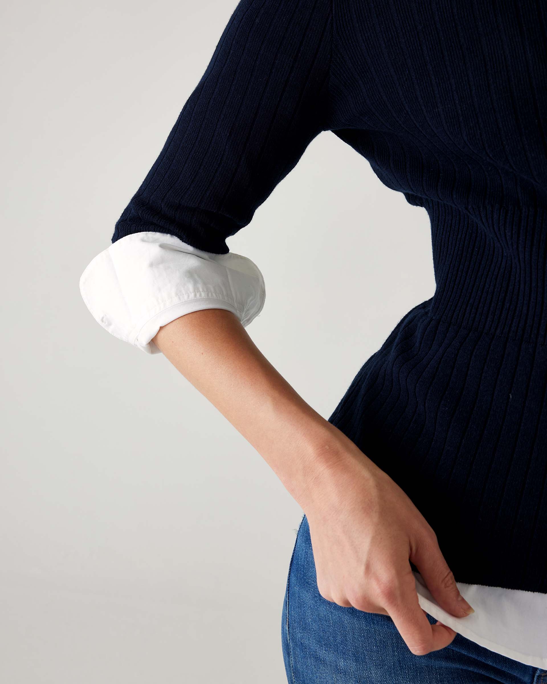 closeup of sleeve on woman wearing mersea acton rib knit navy top