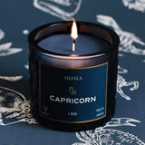 Mersea Capricorn scented candle set against an astrology sign-themed backdrop