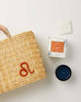 Mersea Leo candle next to candle box and medina bag on white background