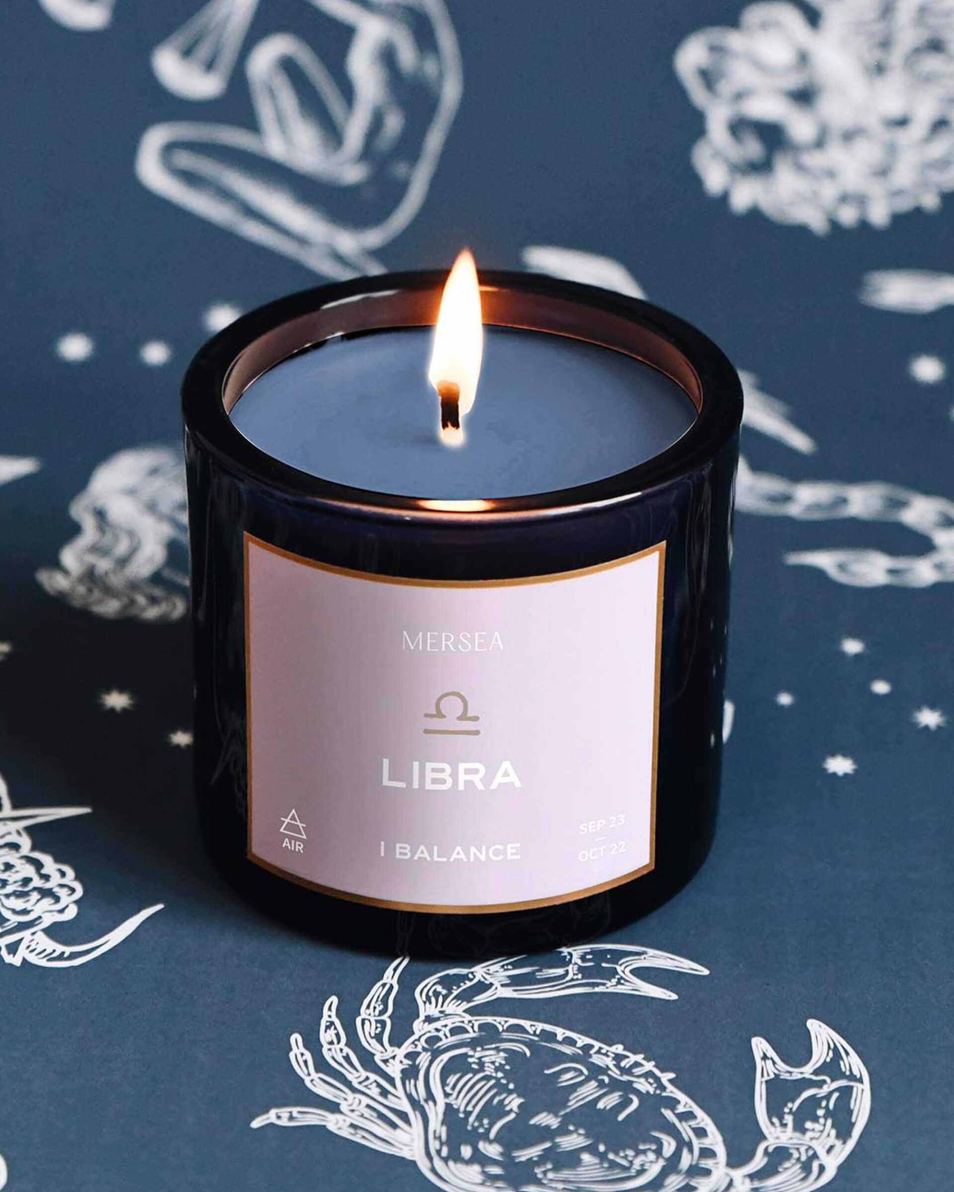 Mersea Gemini scented candle set against an astrology sign-themed backdrop