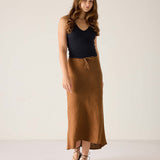 Woman wearing a black top and brown skirt on a white background