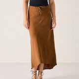 Person wearing a brown skirt and black top on a white background