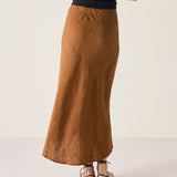 Person wearing a long brown skirt on a white background