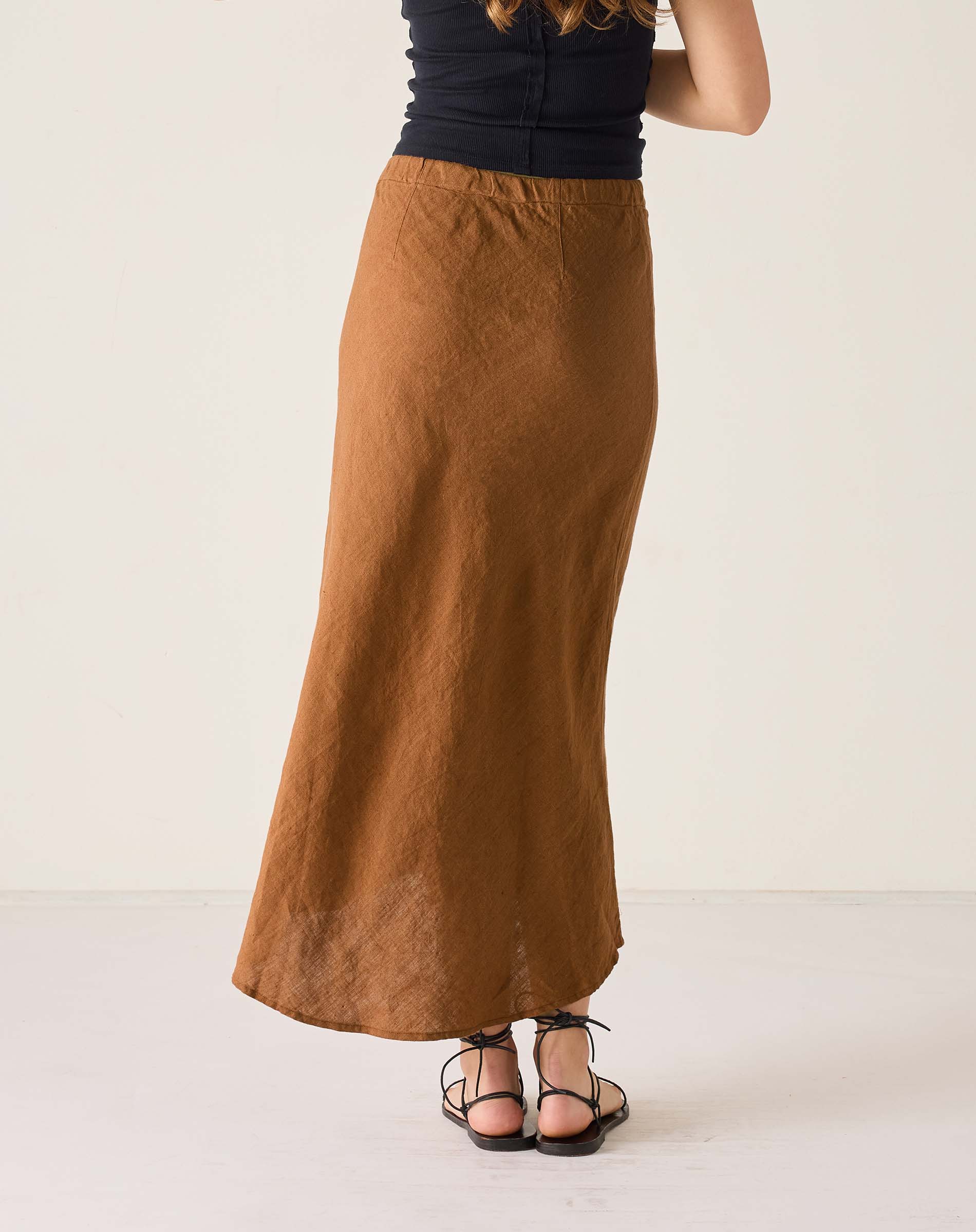 Person wearing a long brown skirt on a white background