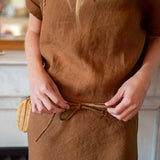 Person wearing a brown dress with a blurred background
