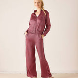 Ladies' travel-ready mauve and white polka dot button-up shirt paired with matching wide-leg trousers.