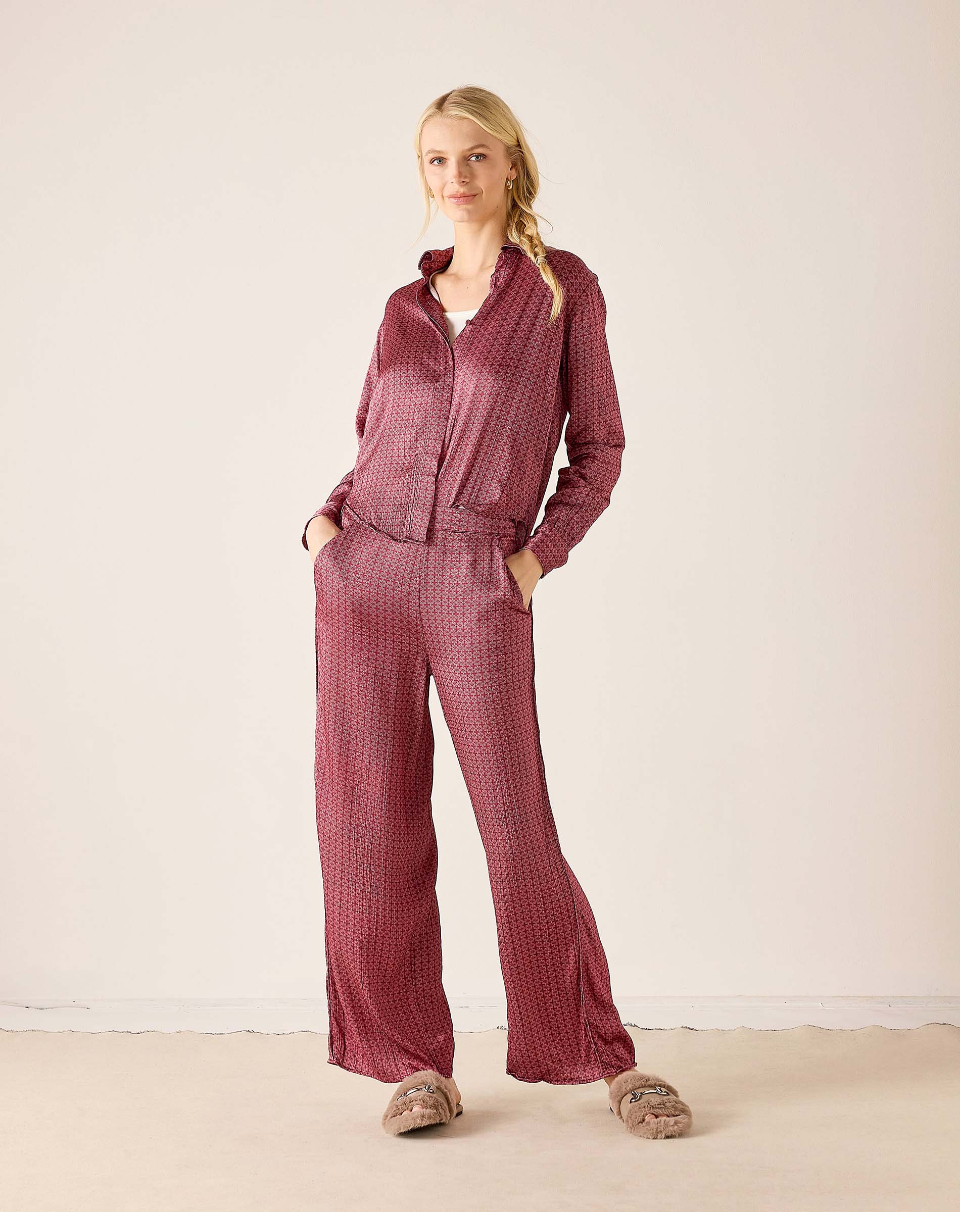 Ladies' travel-ready mauve and white polka dot button-up shirt paired with matching wide-leg trousers.