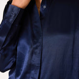 Navy blue button-up shirt in a smooth silk-like fabric with long sleeves and a relaxed fit.