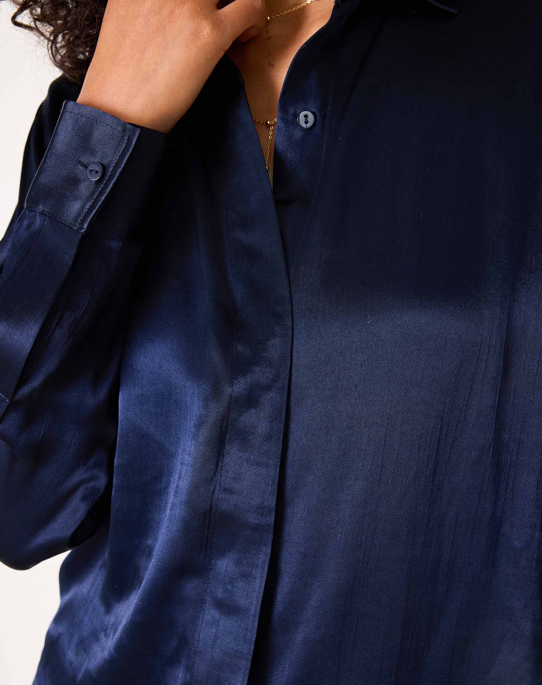 Navy blue button-up shirt in a smooth silk-like fabric with long sleeves and a relaxed fit.