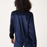 Back view of women's travel-friendly navy button-up shirt in a smooth satin-finish fabric.