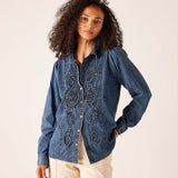 Ladies' travel-ready bleu chambray button-down shirt featuring intricate tonal embroidery and a tailored fit.