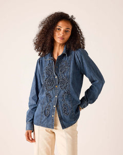 Ladies' travel-ready bleu chambray button-down shirt featuring intricate tonal embroidery and a tailored fit.