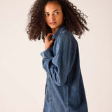 Bleu chambray shirt featuring an oversized relaxed fit, button-front design, and decorative embroidery detail.