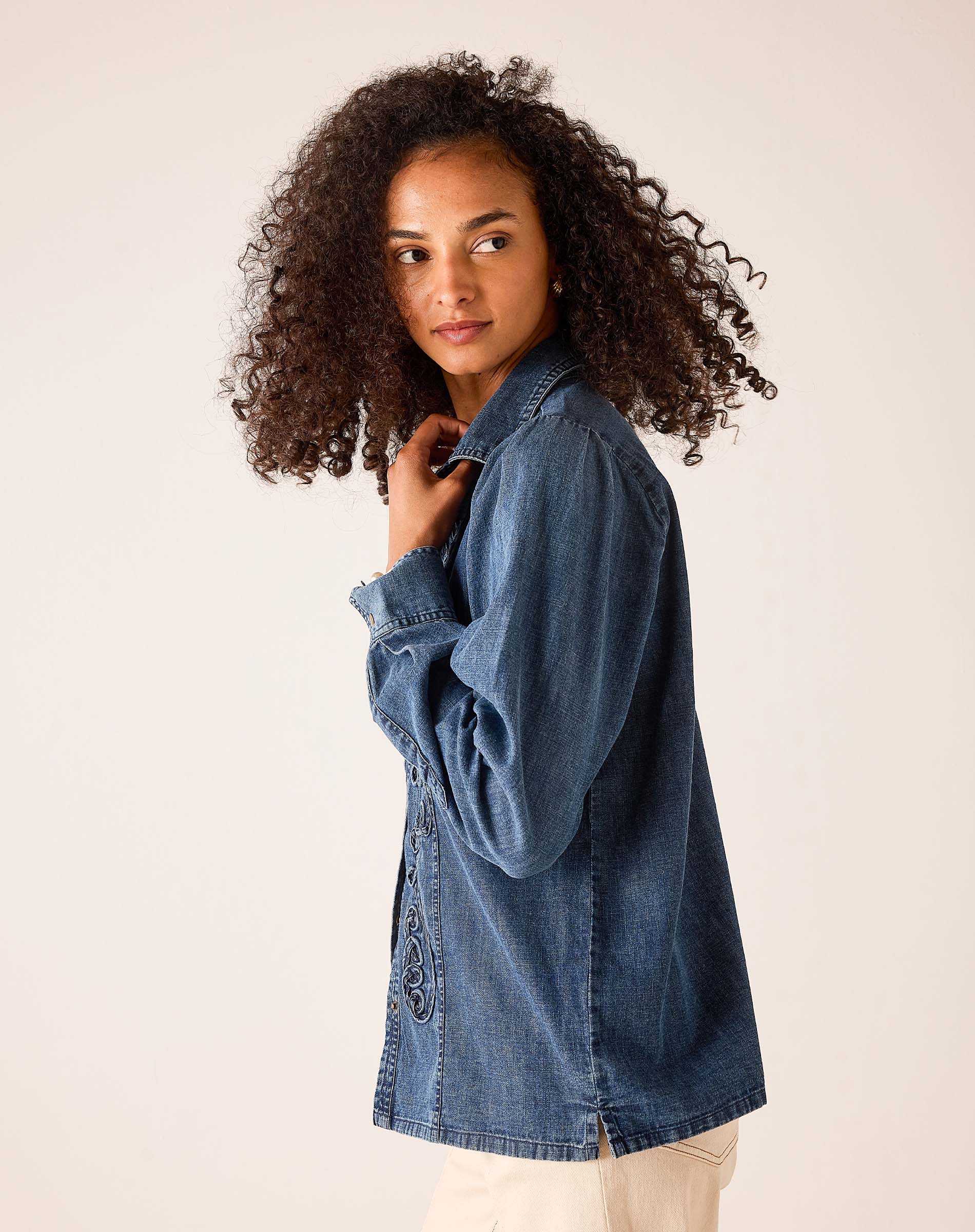 Bleu chambray shirt featuring an oversized relaxed fit, button-front design, and decorative embroidery detail.