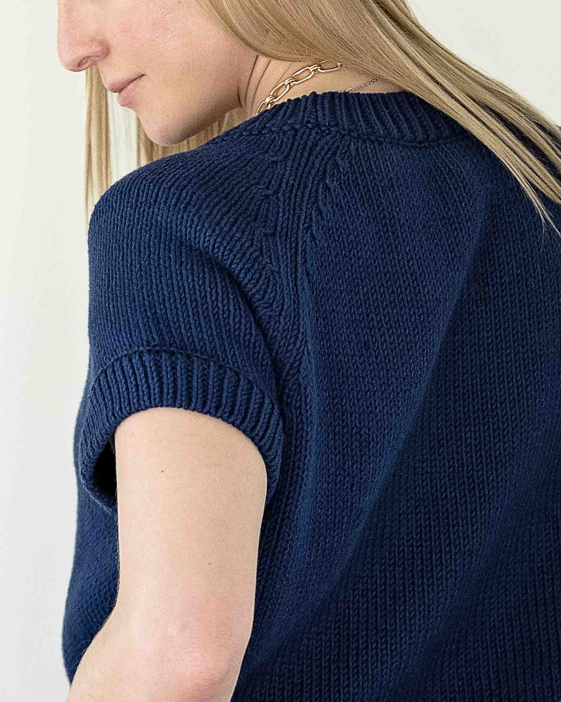 woman wearing navy short sleeve sweater shoulder view