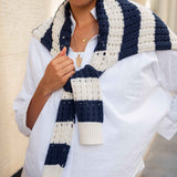 Person wearing a blue and white striped scarf with a neutral background