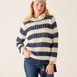 Woman wearing a navy and white striped sweater with blue jeans on a beige background