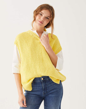 female wearing yellow crewneck knit sweater vest standing on a white background