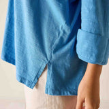 Blue shirt worn by a person with a neutral background