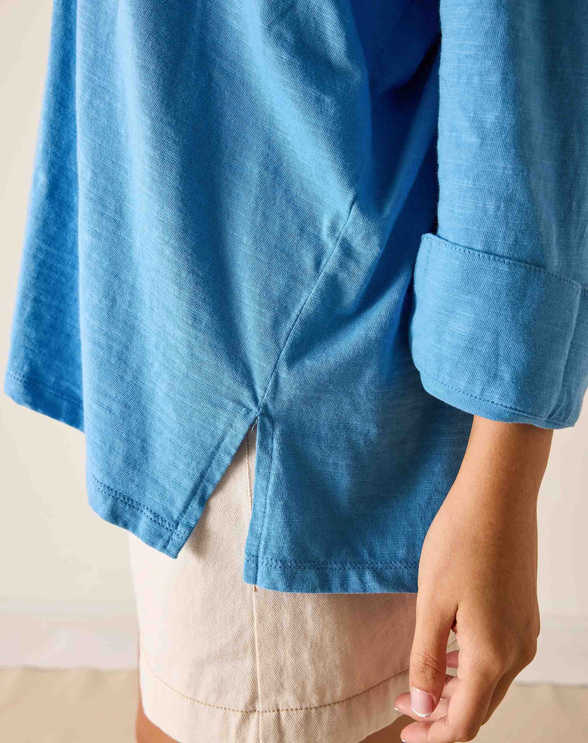Blue shirt worn by a person with a neutral background