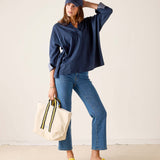 MERSEA ladies' travel-ready navy chambray tee with cuff details and light blue denim jeans.